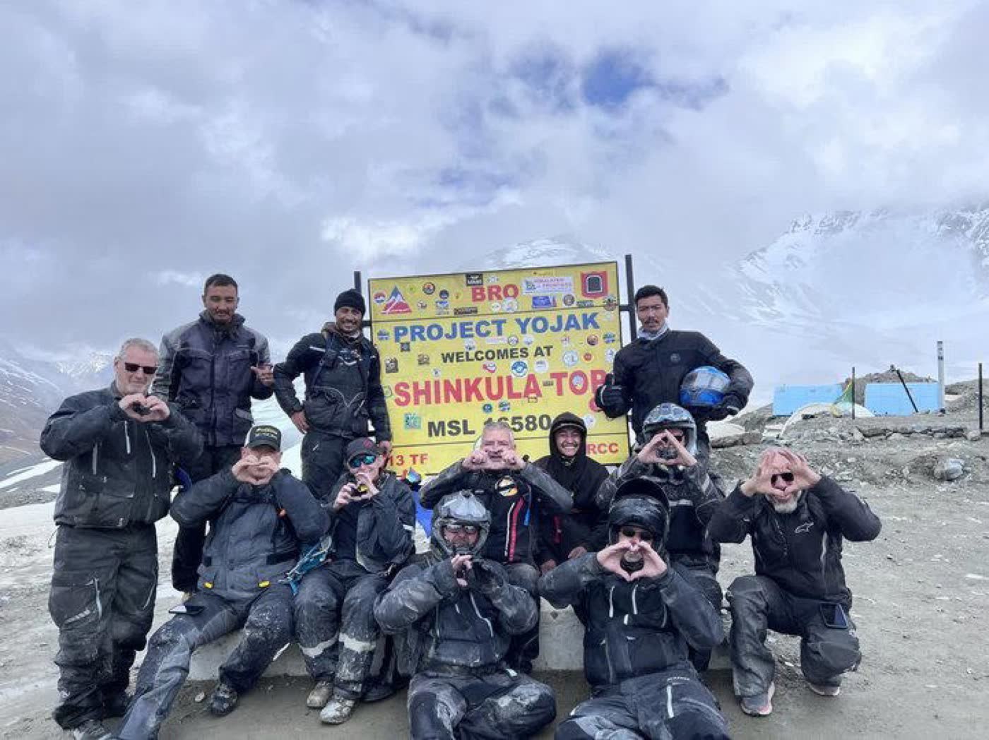 Riders gathered at the Shinkula Top pass sign in Zanskar